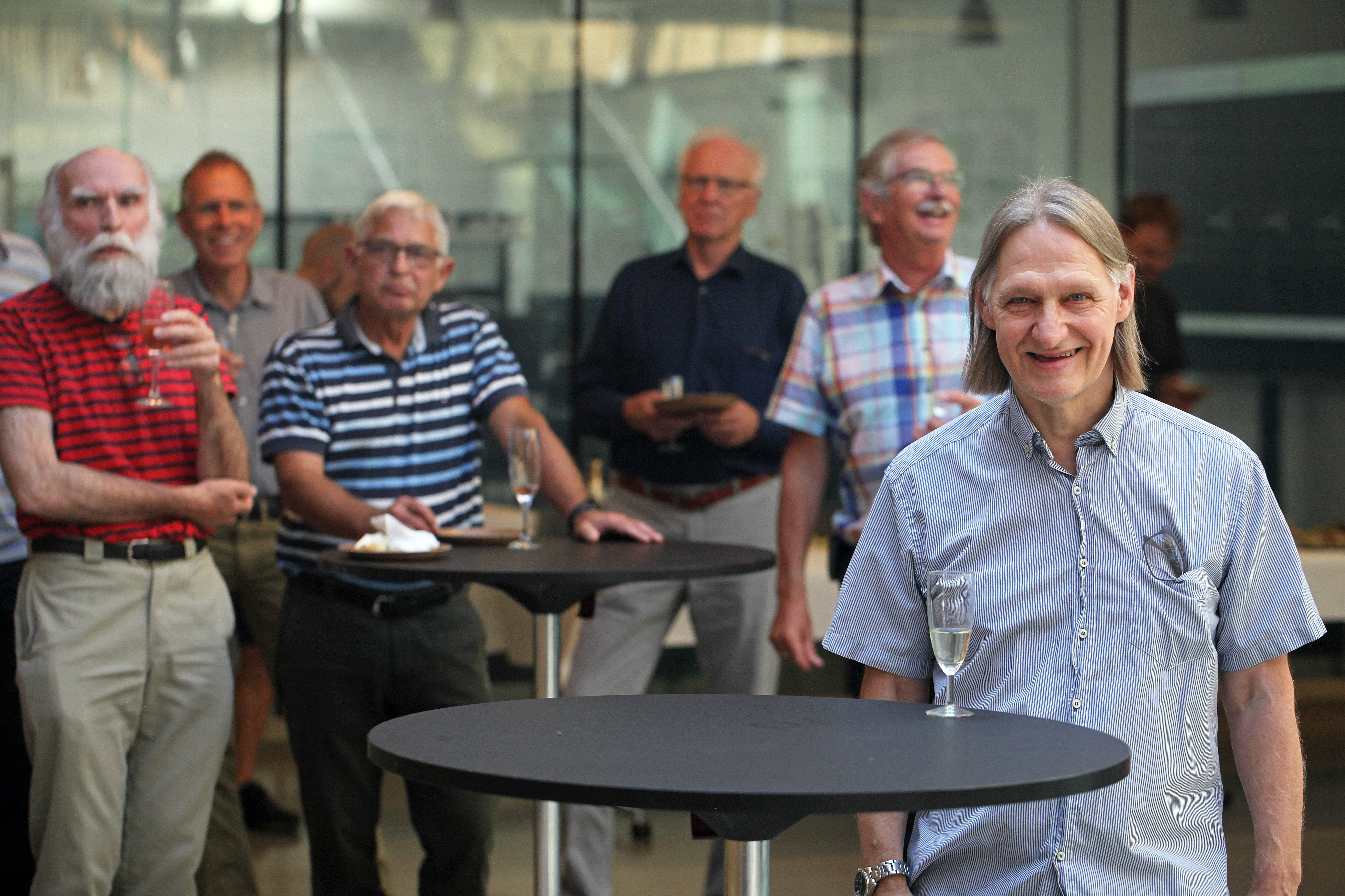Nils Axel Andersen smiling and standing in front of a row of colleagues