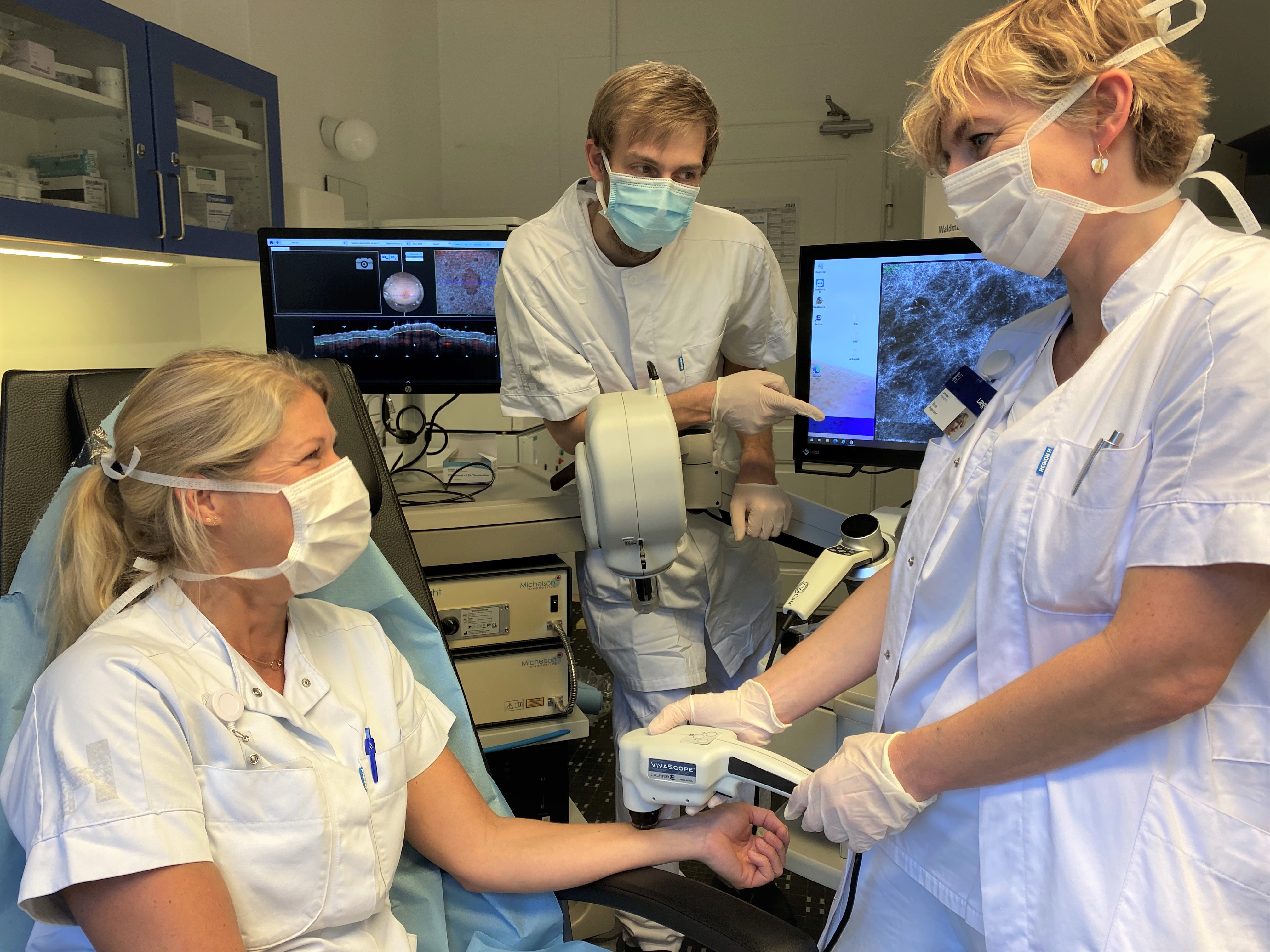 Chief physician and clinical associate professor at the Department of Dermatology at Bispebjerg Hospital Mette Mogensen (right) works with DTU Fotonik researcher Niels Møller Israelsen (center) to provide faster cancer diagnoses using imaging. Here, one of the Department of Dermatology's research nurses is being scanned.