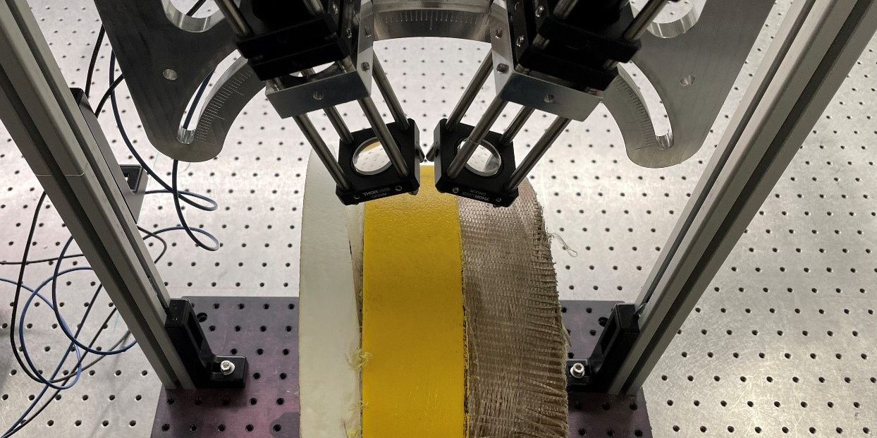 Laboratory image of a piece of flexible oil pipe being inspected with terahertz. The white, brown and yellow layers are stacked on top of each other and can be inspected simultaneously.